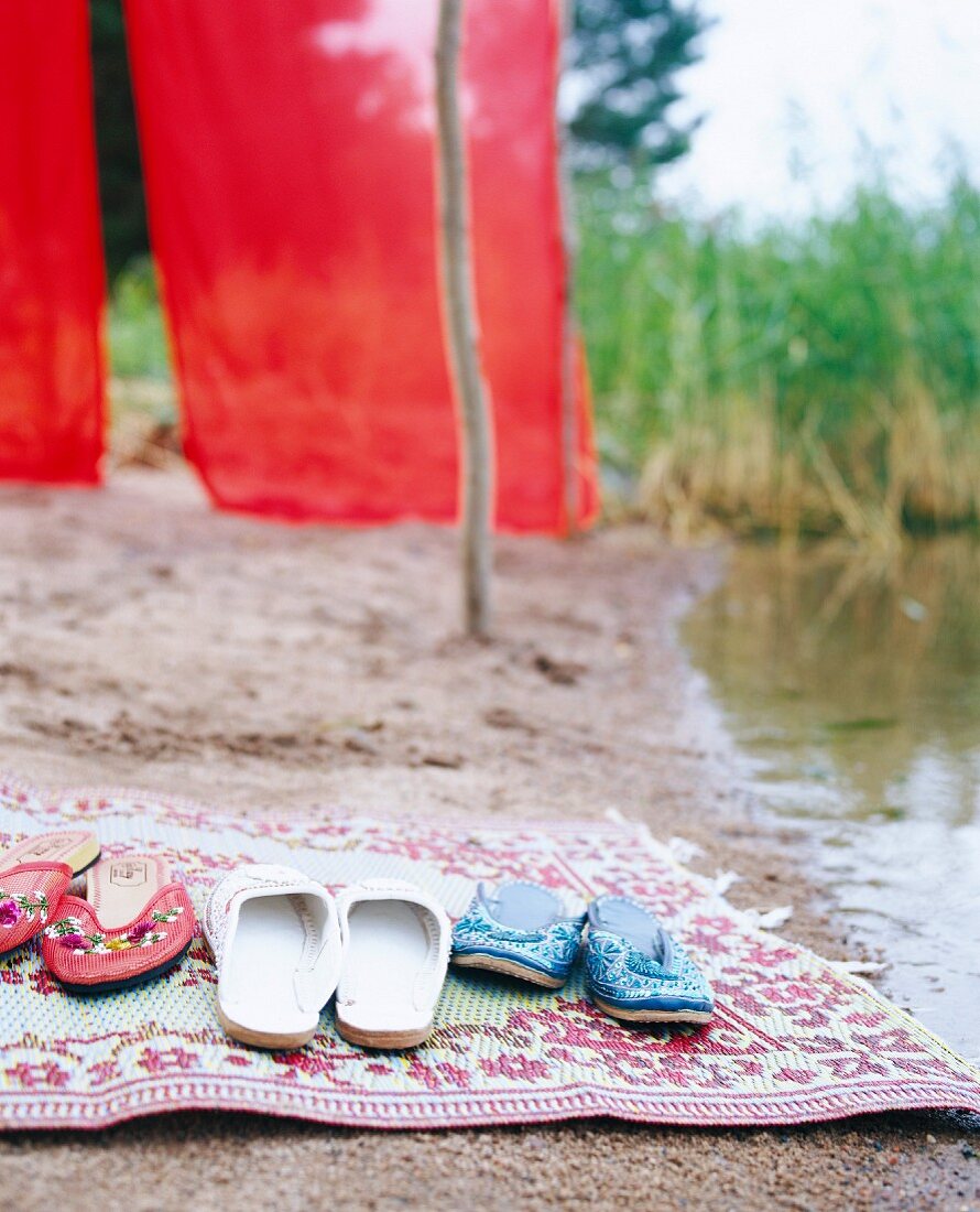 Slippers on rug on beach