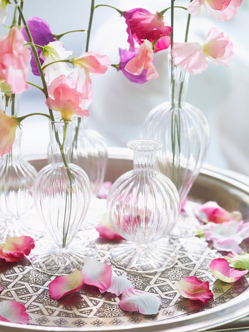 Small vases of delicate pastel flowers