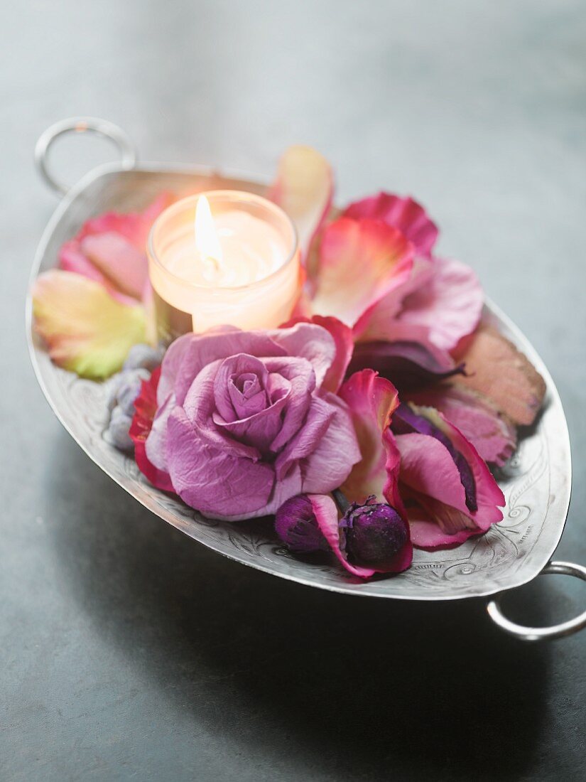 Tealight, petals and purple rose in silver dish