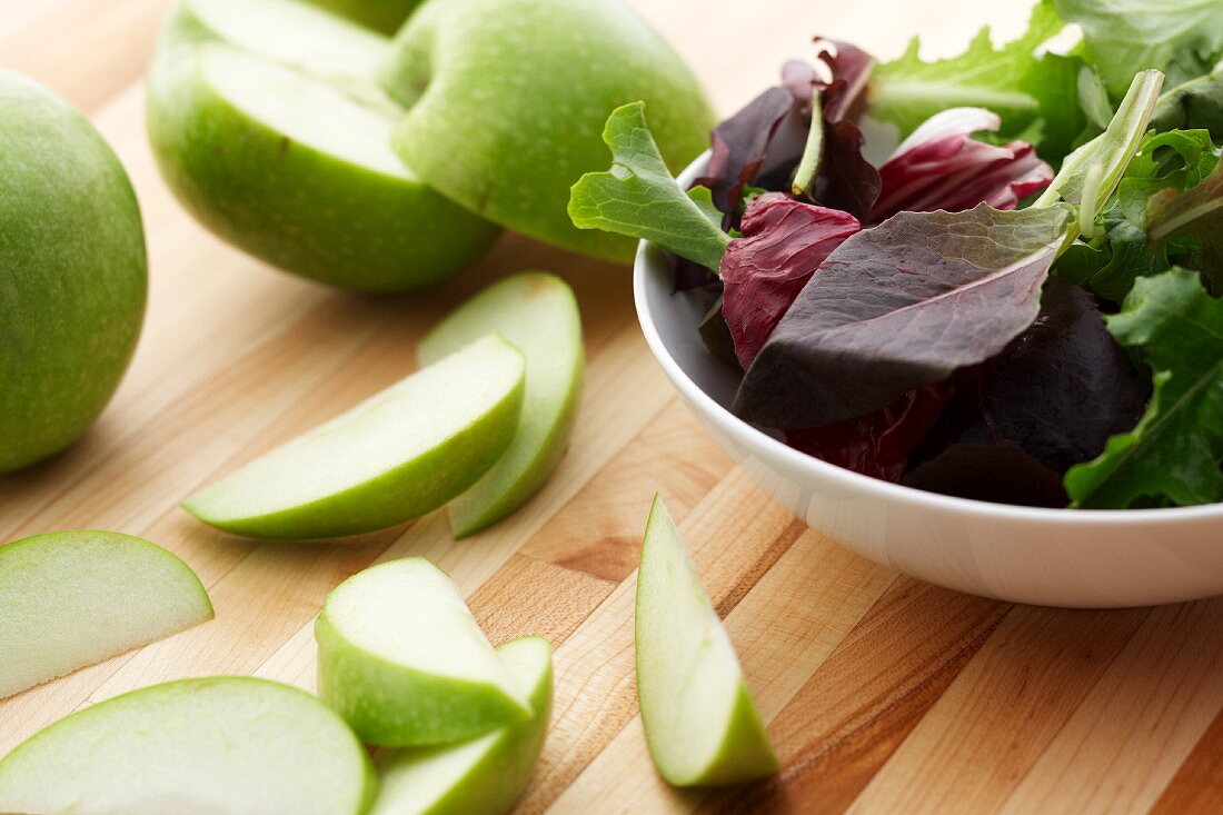 Gemischte Salatblätter und Apfelschnitze