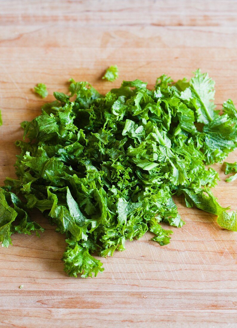 Chopped mustard greens on a wooden Cutting Board