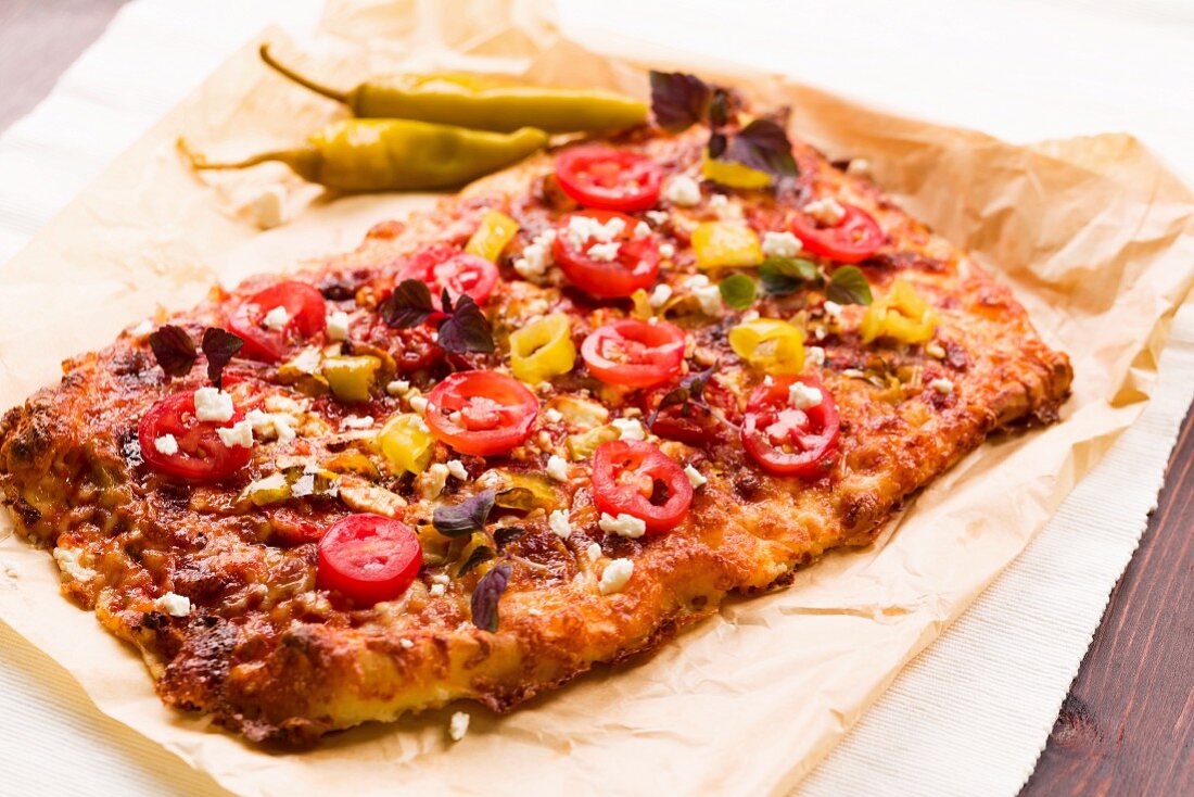 Pizza topped with hot peppers, feta and fresh tomatoes
