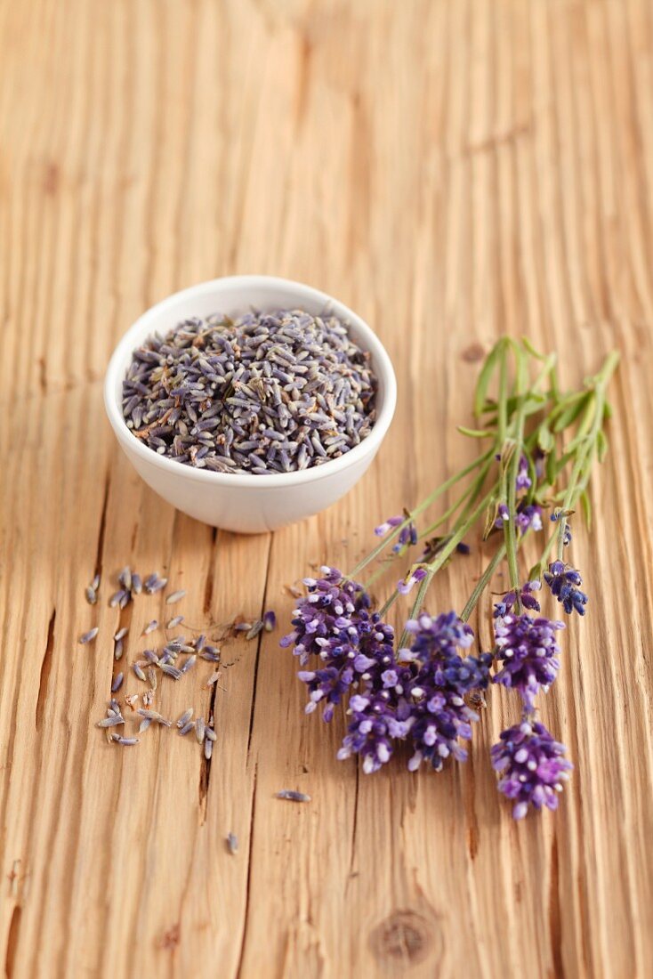 Lavender flowers (fresh and dried) on a wooden surface