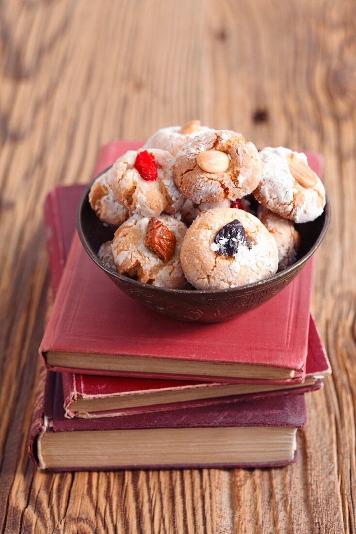 Amaretti (almond biscuits, Italy) with dried fruits on a stack of books