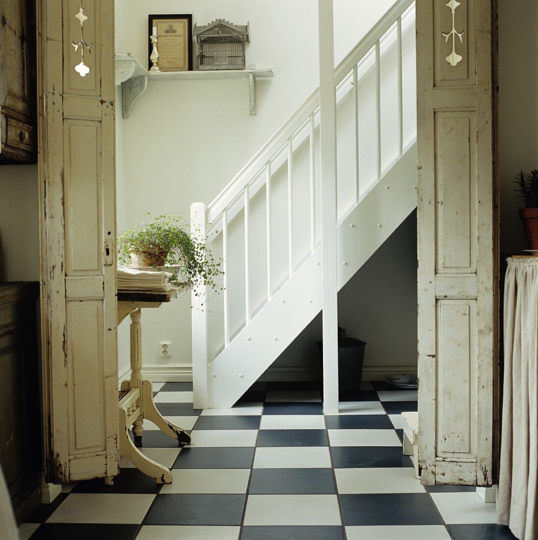 Snow-white, country-house staircase, traditional, chequered tiled floor and folding doors with peeling paint