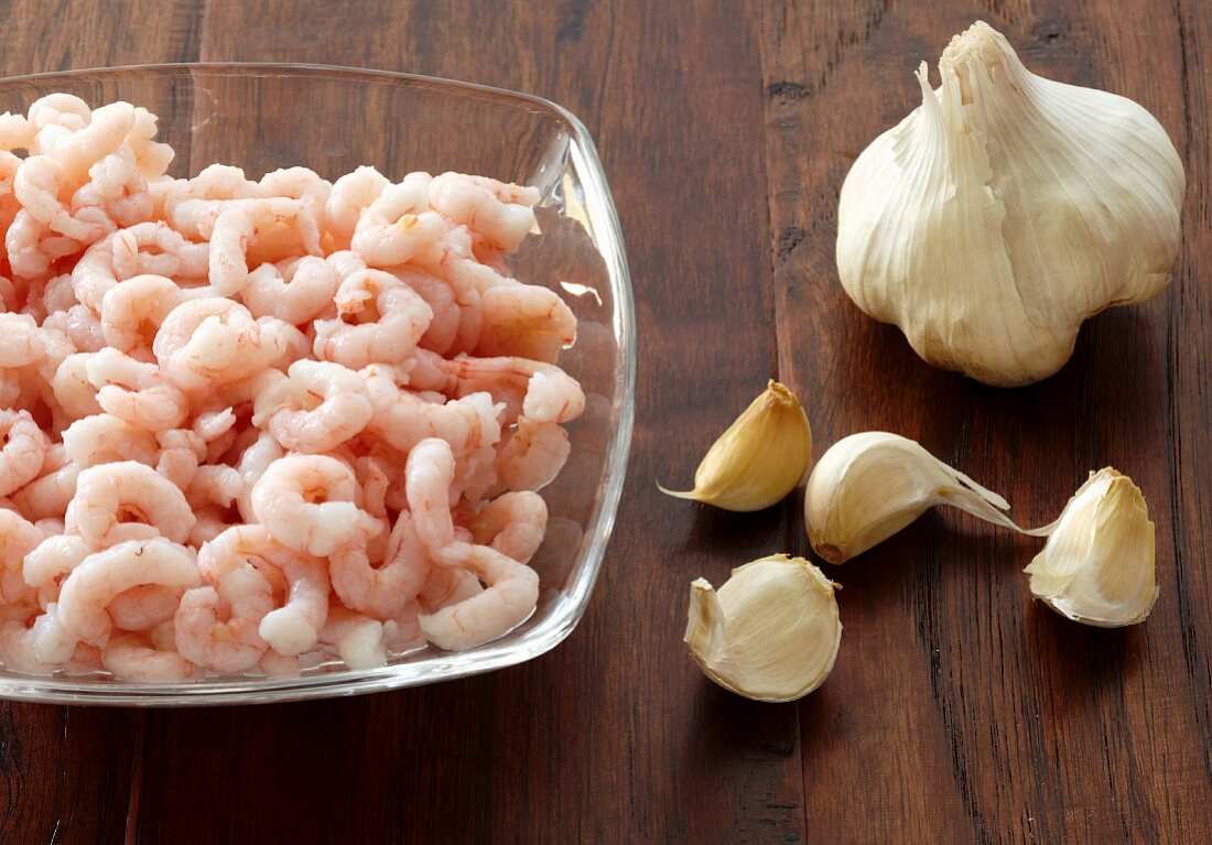 A Bowl of Shrimp and a Bulb of Garlic with Separated Cloves