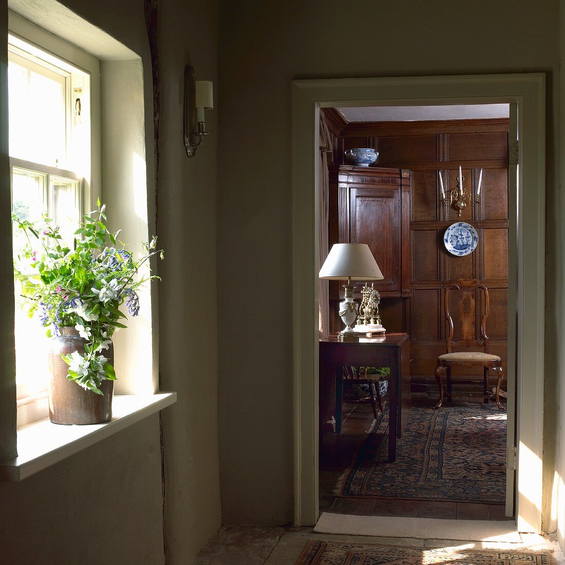 View through open interior door into dignified interior with solid wooden panelling