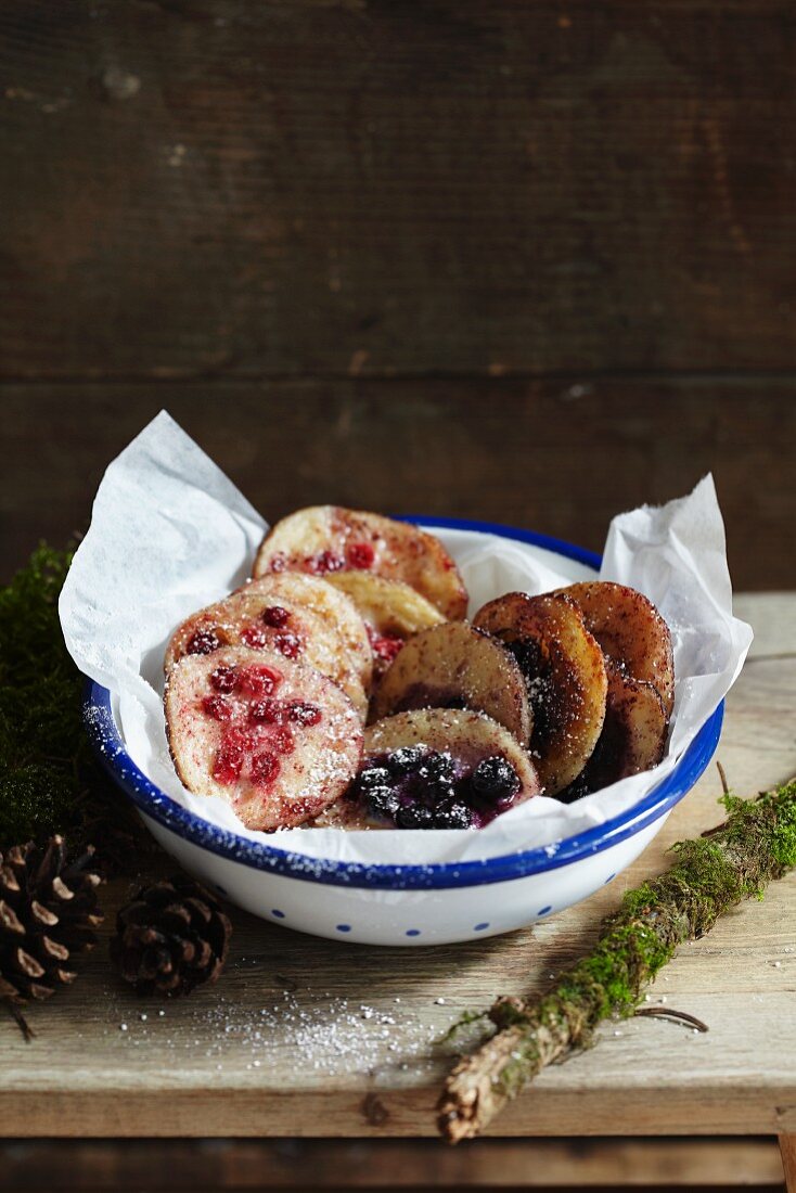 Kleine Pfannkuchen mit Beeren in rustikaler Schüssel