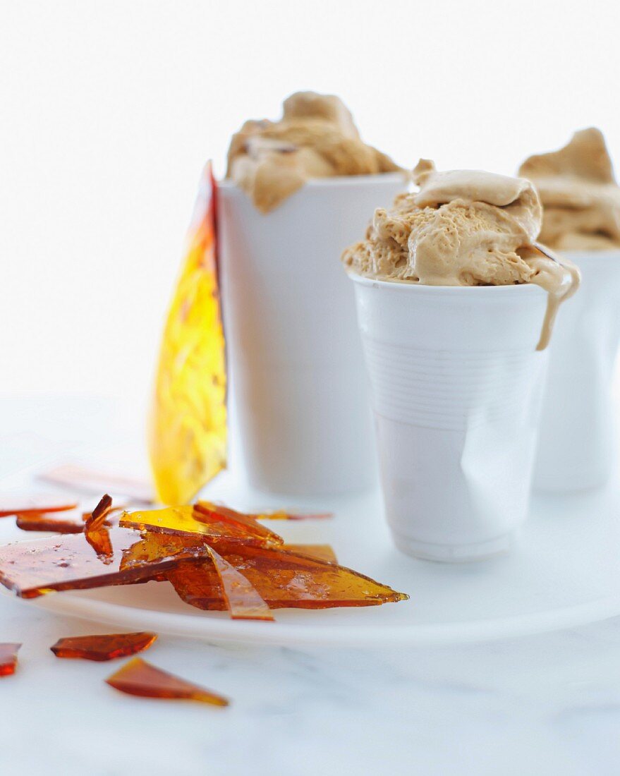 Still life with cups of salted caramel ice cream and toffee shards
