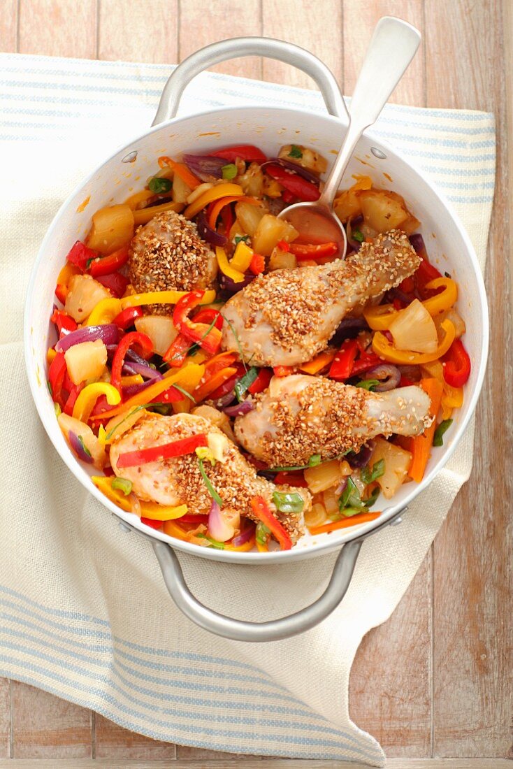 Chicken legs with sesame seeds, peppers and pineapple