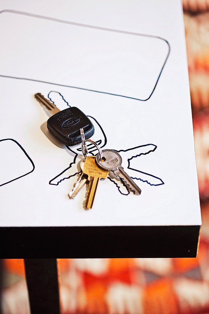 Bunch of keys and traced outline on white table