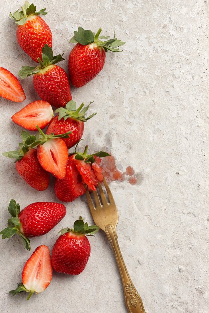 Fresh strawberries, some crushed with a fork