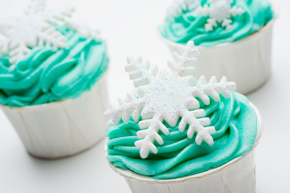 Cupcakes mit grünem Frosting und Schneeflocke verziert