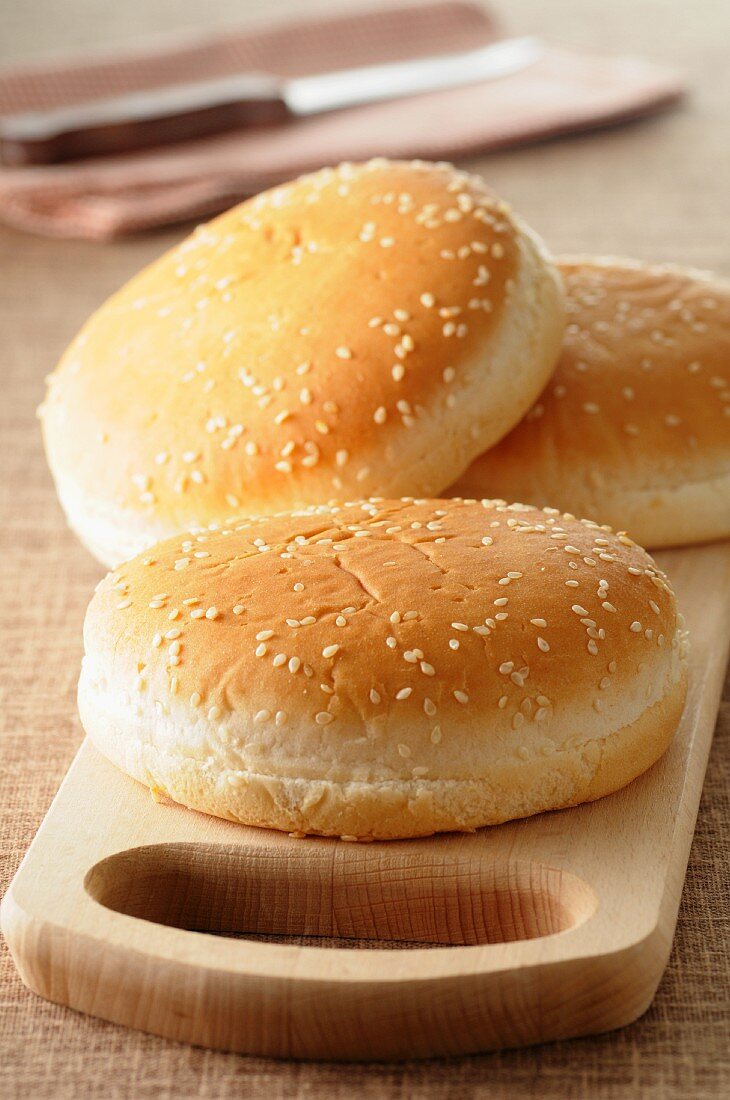 Three hamburger buns with sesame seeds