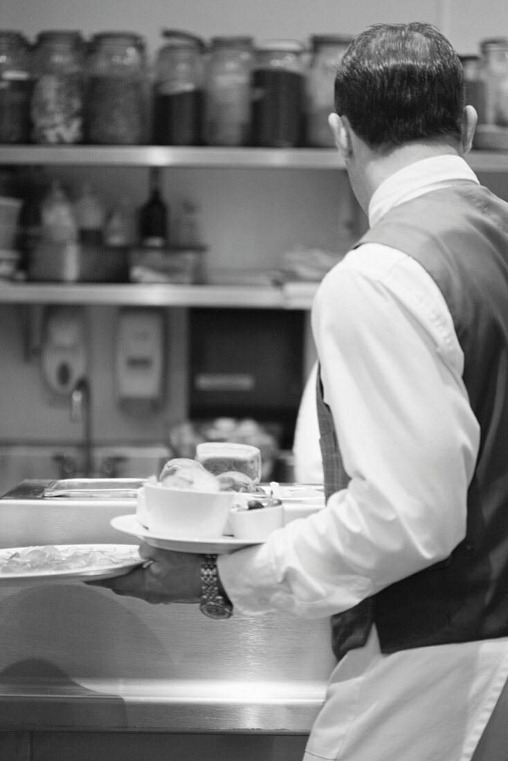 Waiter carrying plates in restaurant