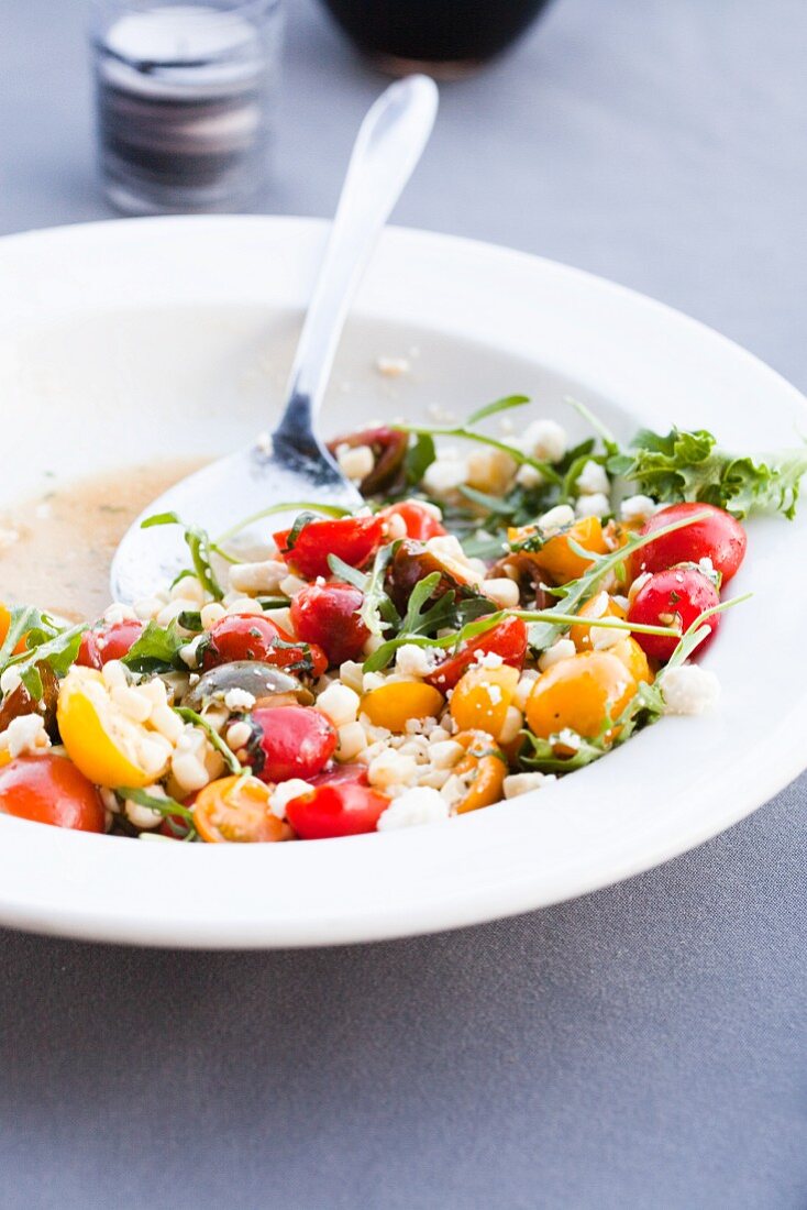 Cherry Tomato Salad with Corn and Ricotta and Arugula in a White Bowl