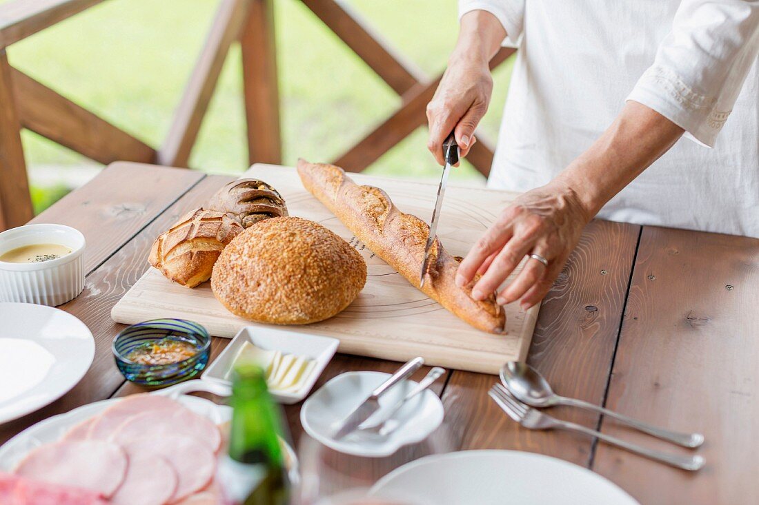 Frau schneidet Baguette in Scheiben