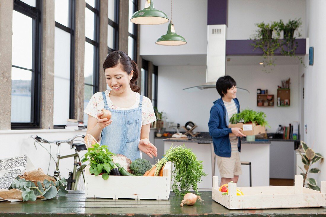 Junge Frau und junger Mann nach dem Gemüsekauf in der Küche