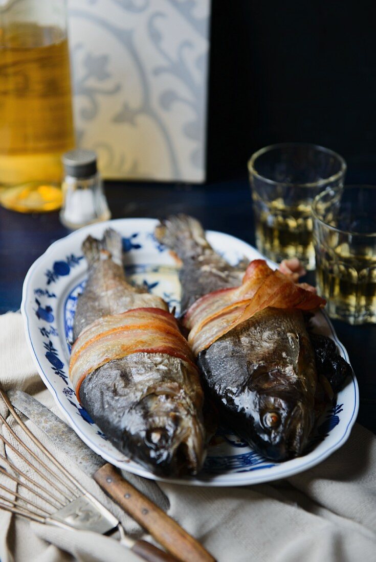 Two trout stuffed with prunes and chestnuts, wrapped in bacon
