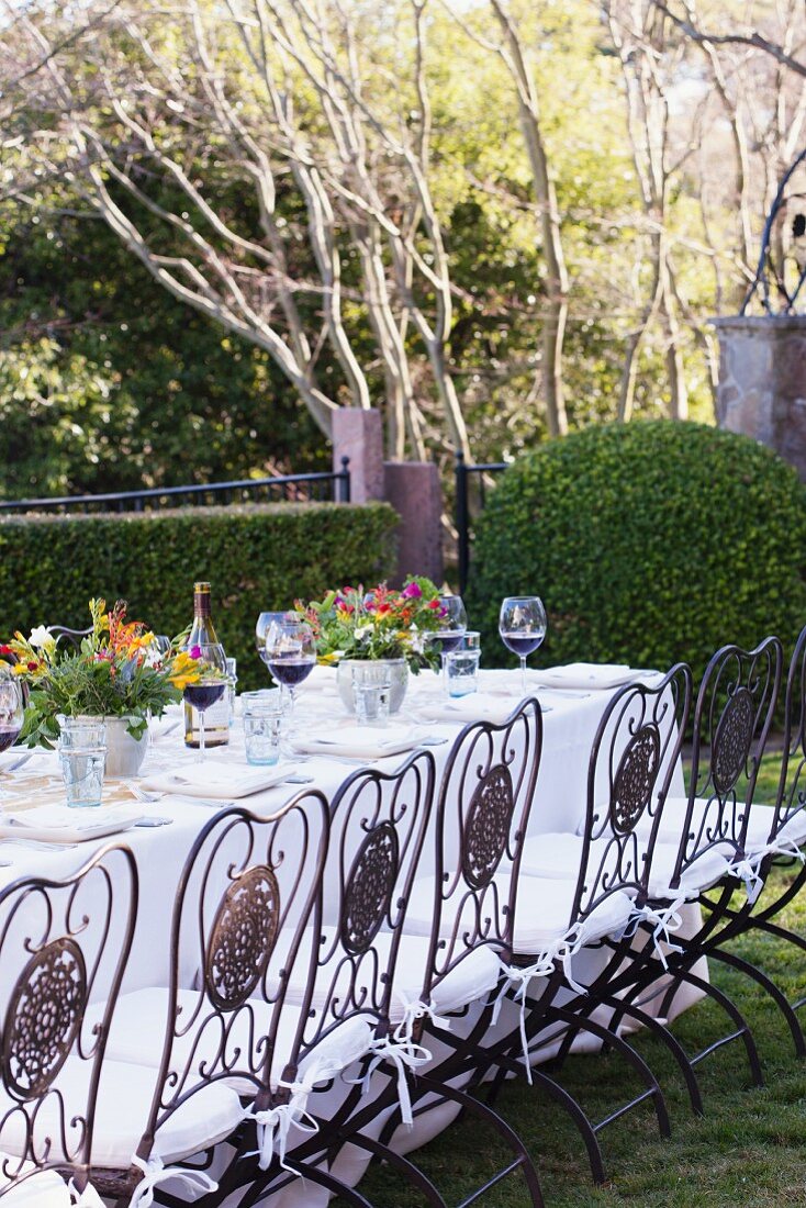 Festlich gedeckter Gartentisch mit fröhlichen Blumensträussen