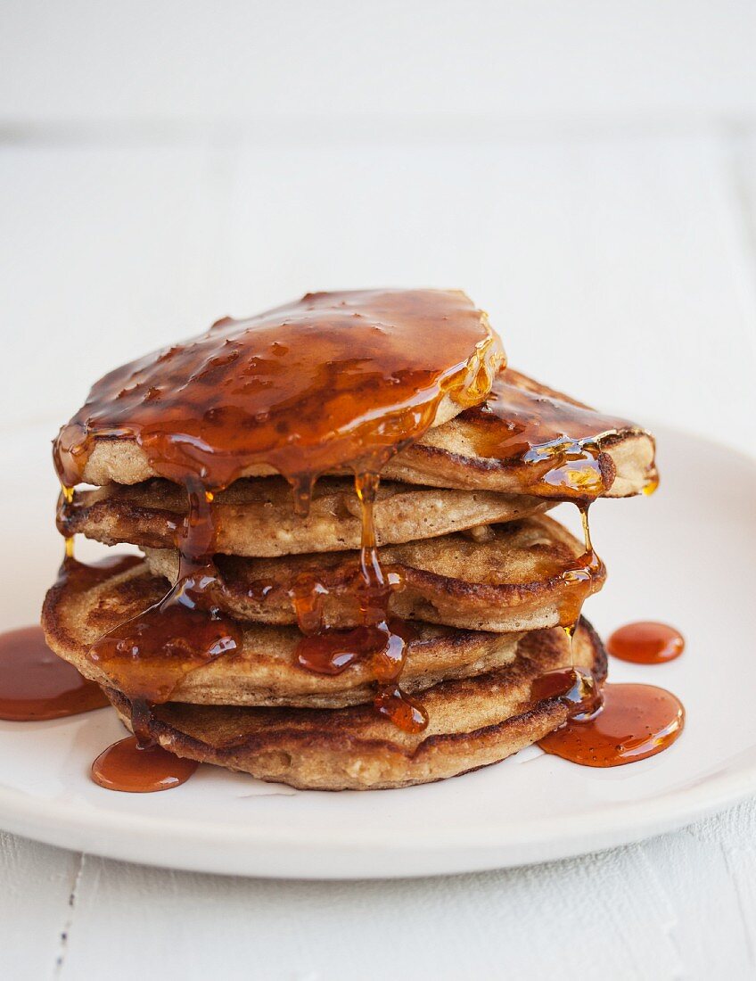 A stack of pancakes with orange syrup