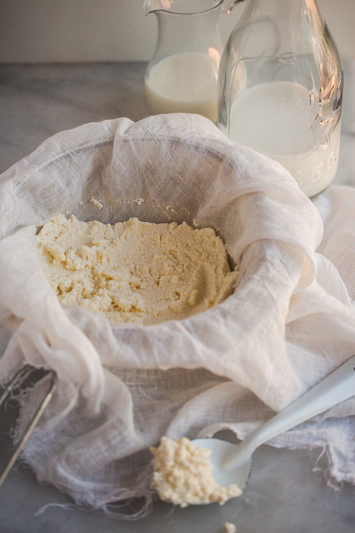 Home-made ricotta in a muslin cloth in a sieve