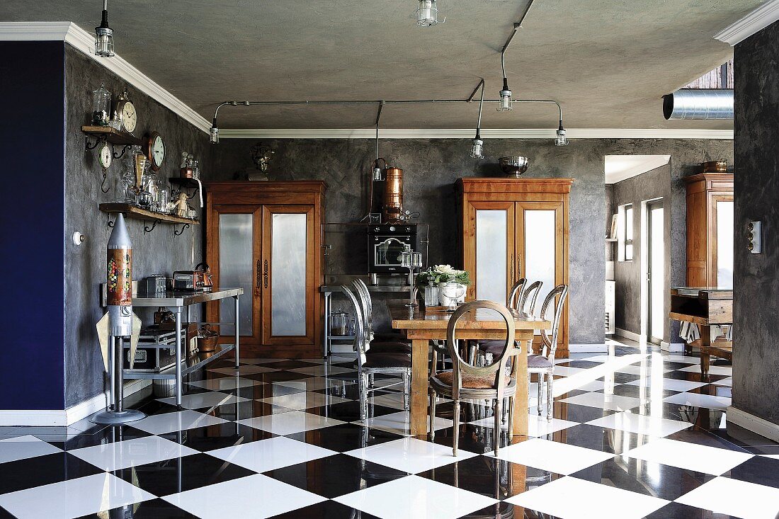 Antique, Victorian elements and industrial style in open-plan interior with reflective chequered floor tiles and dark grey marbled walls