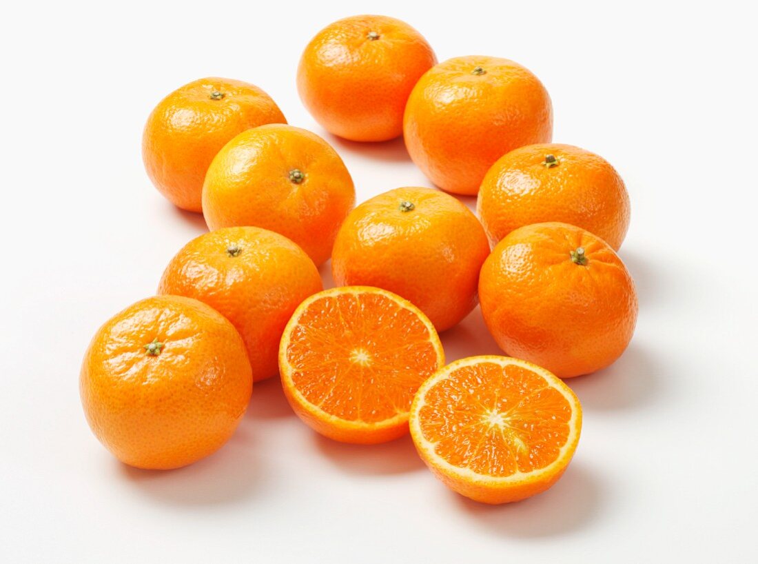 Mehrere Clementinen, ganz und halbiert