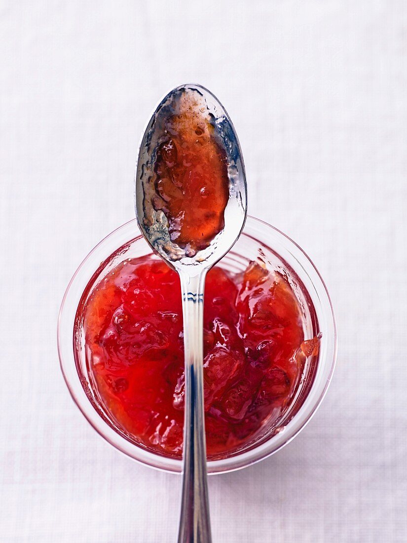 Pflaumen-Birnen-Marmelade im Glas mit Löffel (Draufsicht)