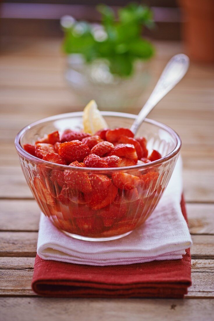 Fresh strawberries with lemon in a glass bowl