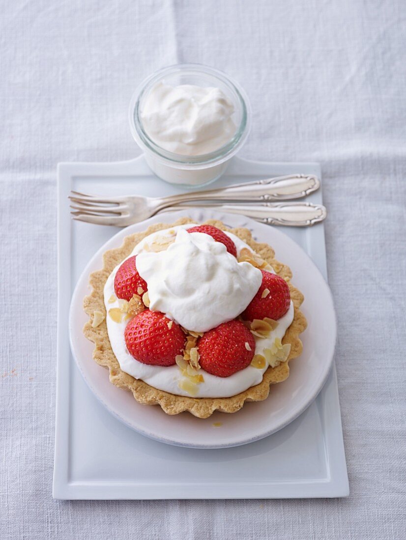 Strawberry tartlet with cream and flaked almonds