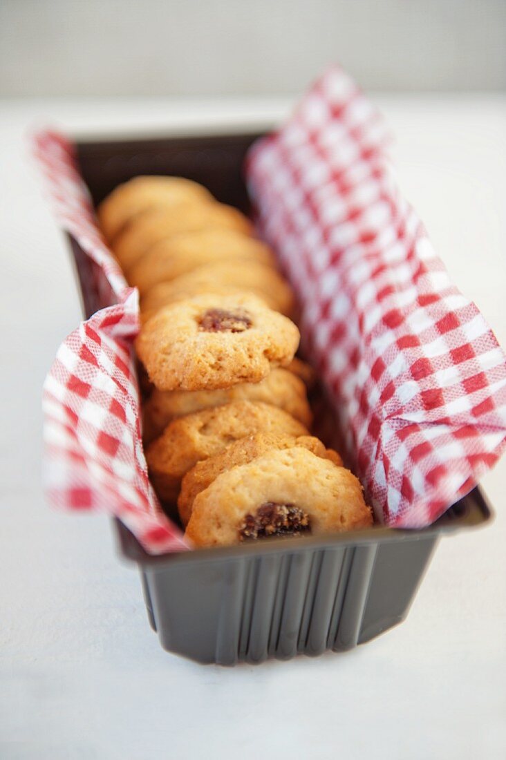 Jam biscuits on a checked napkin in a loaf tin