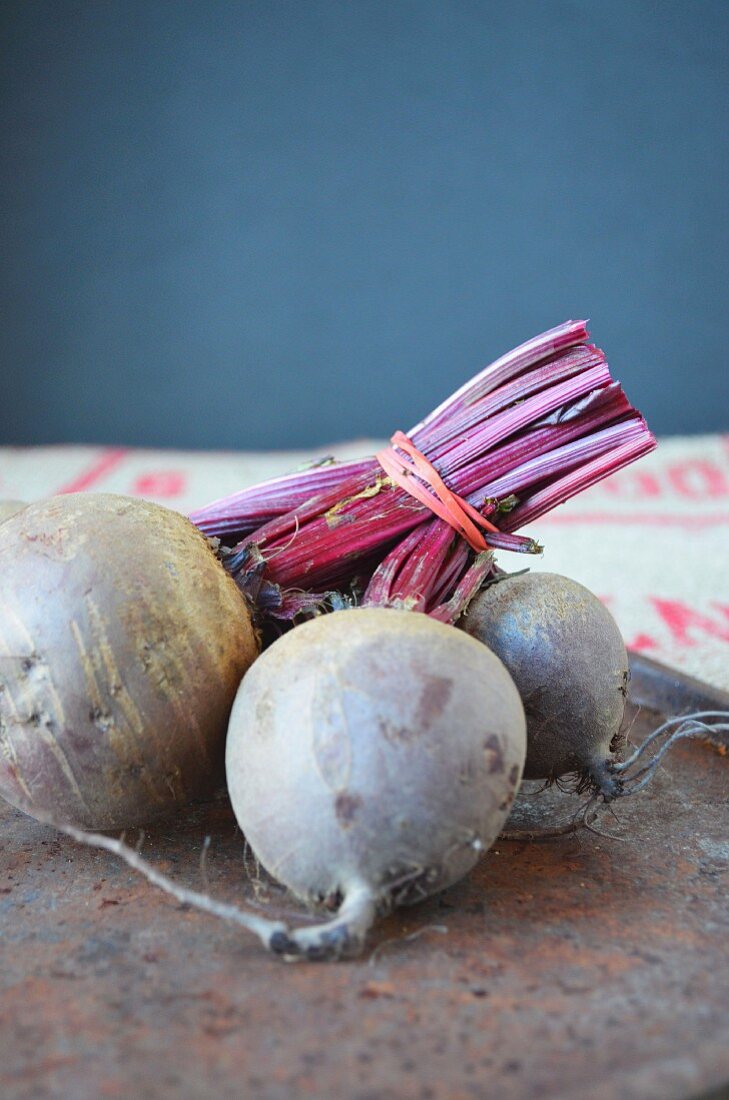 A bunch of raw beetroots on a rusted metal tray