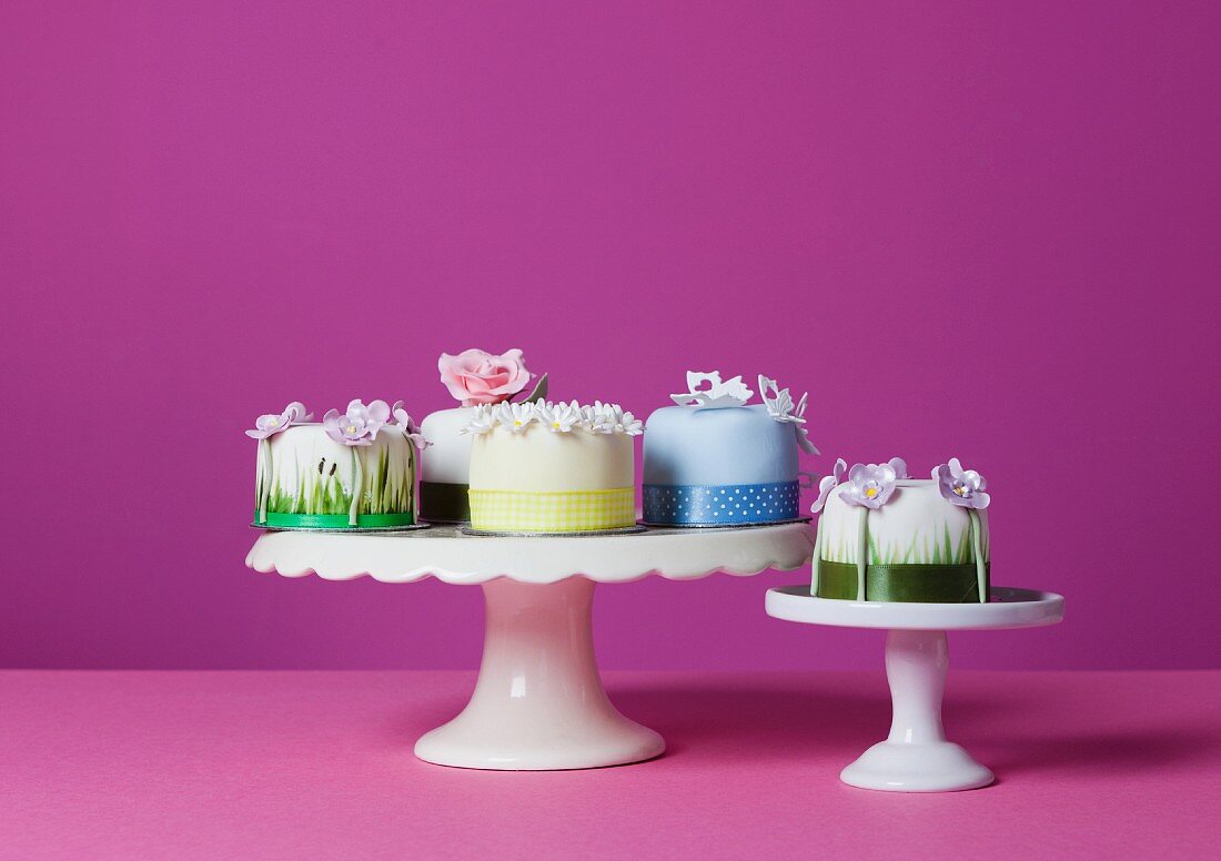 Several small celebration cakes on cake stands