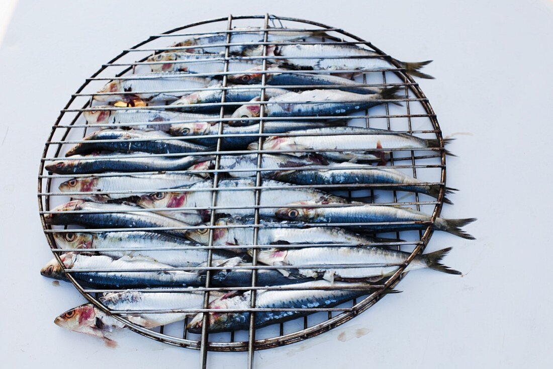 Raw sardines in a barbecue basket