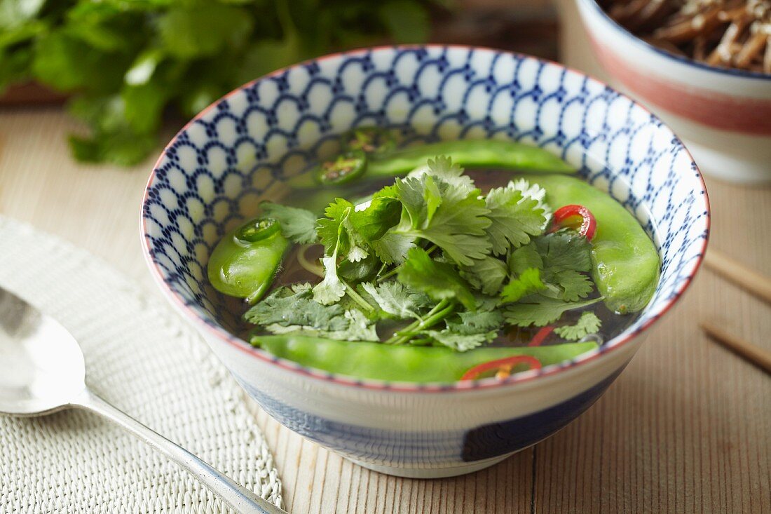 Noodle soup with mange tout and coriander leaves (Asia)