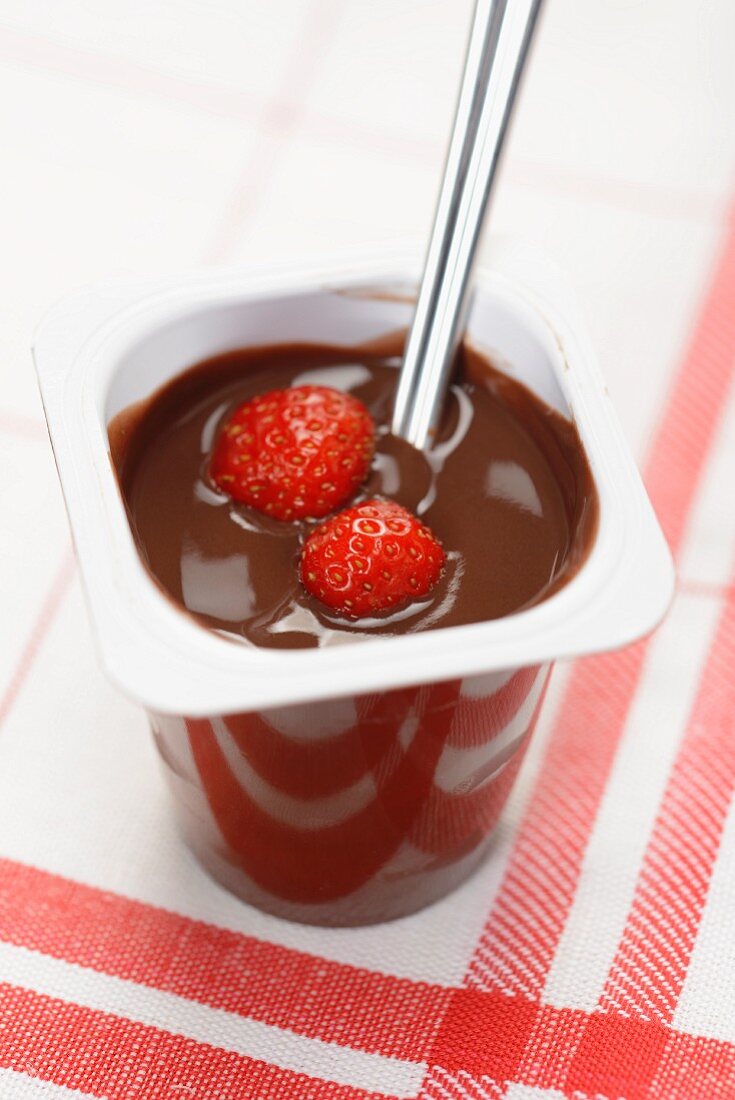 Ein Becher Schokoladenjoghurt mit Erdbeeren