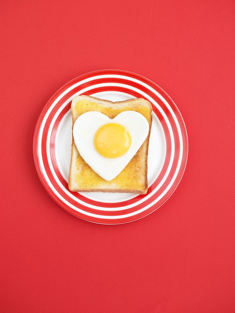Toast topped with a fried egg heart (view from above)