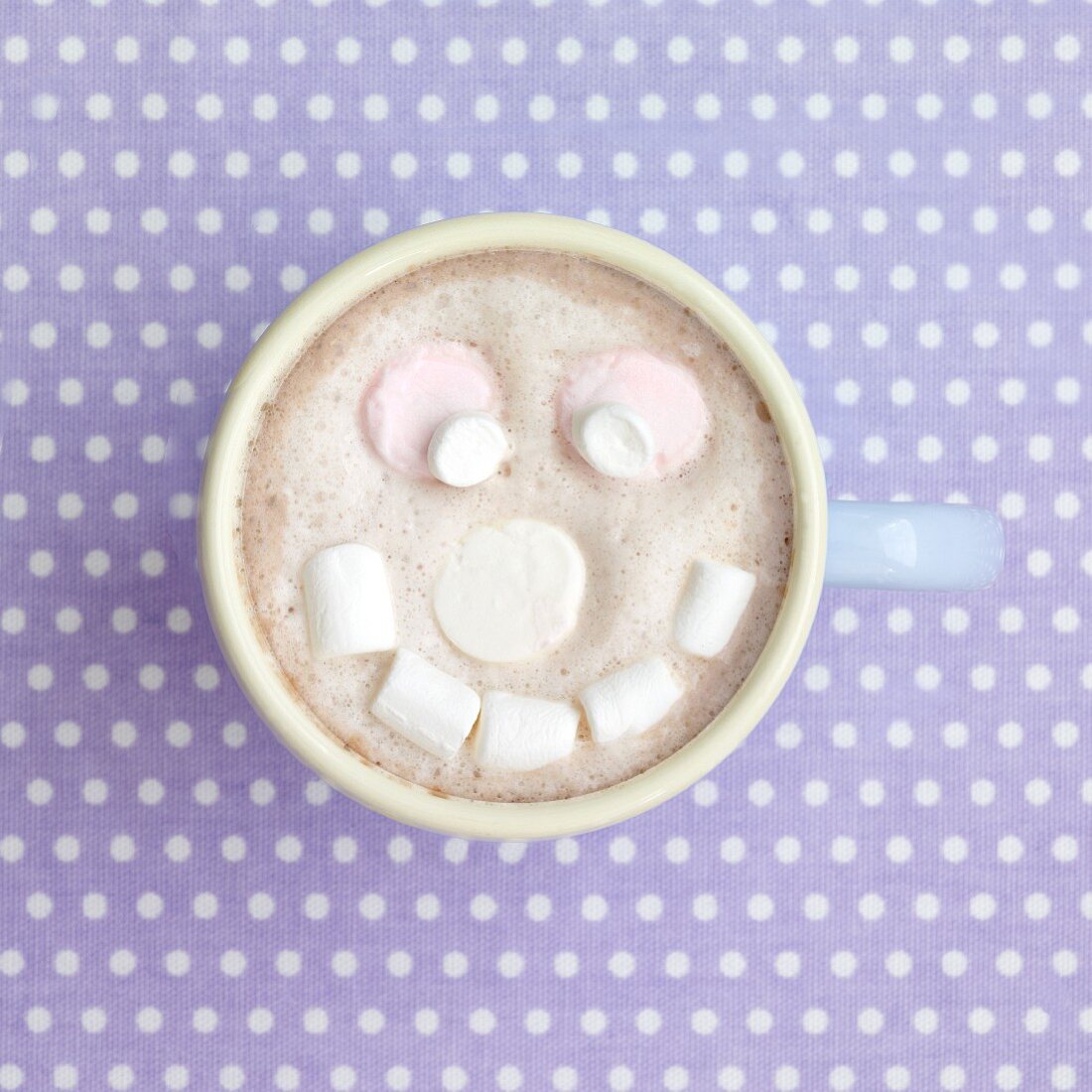 A cup of cocoa with a marshmallow face