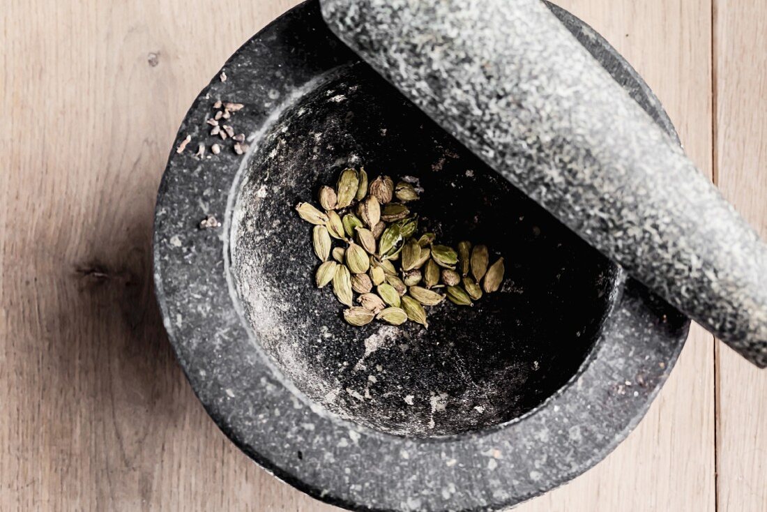 Cardamom pods in a stone mortar (view from above)