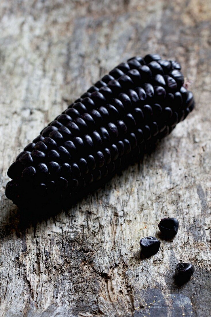Purple corn (Zea mays) from South America, on a wooden surface