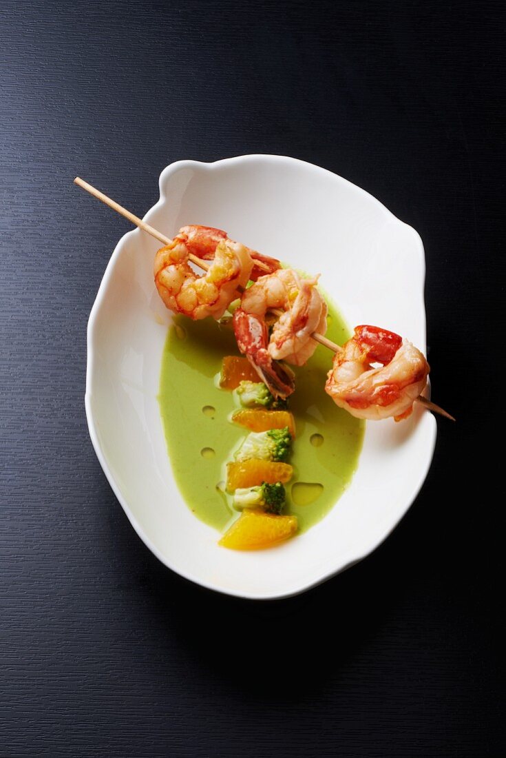 Broccoli soup with oranges and a skewer of prawns