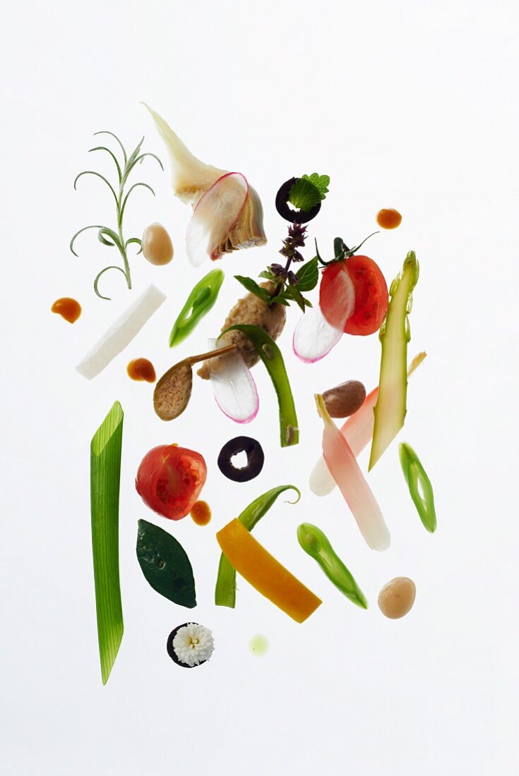 A still life of vegetables and herbs against a white background