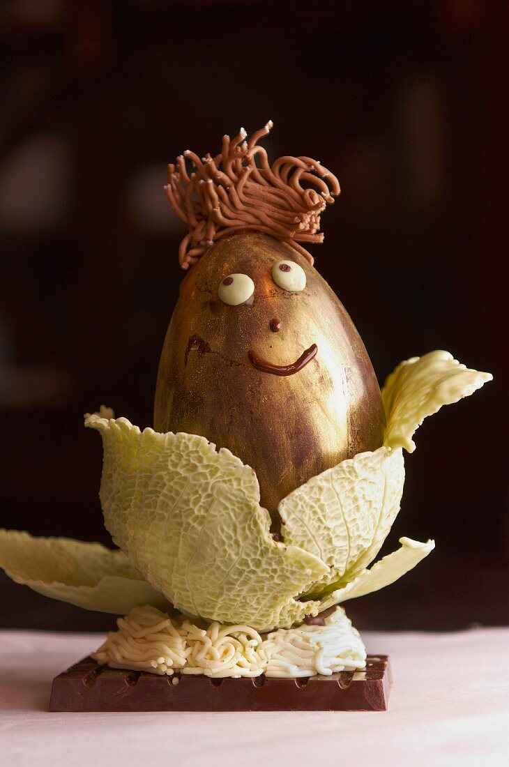 A chocolate egg in a leaf of savoy cabbage made out of white chocolate