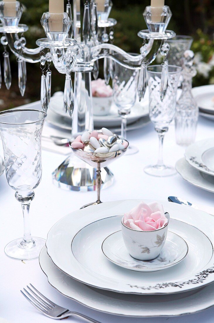 Festlich gedeckte Hochzeitstafel mit Porzellantellern, Kristallgläsern und Kerzenleuchter
