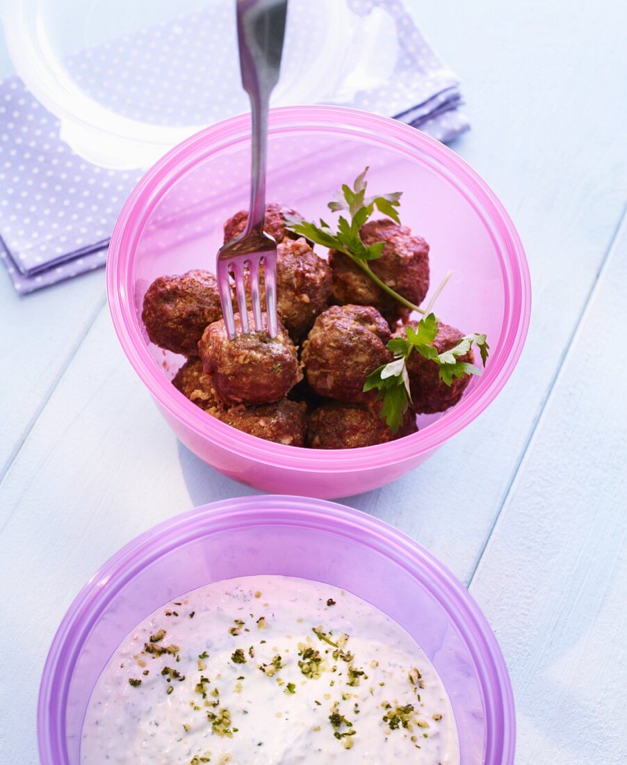 Meatballs with yoghurt sauce in Tupperware containers