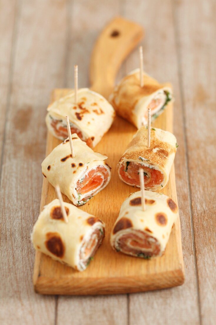 Rolled strips of pancake filled with smoked salmon, cheese and dill