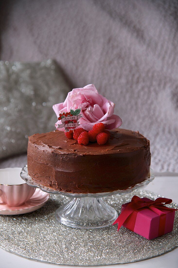Chocolate cake decorated with raspberries and roses for Valentine's Day