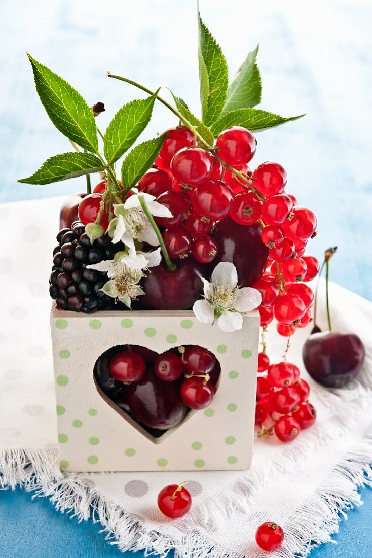 Assorted berries in a wooden box with a heart
