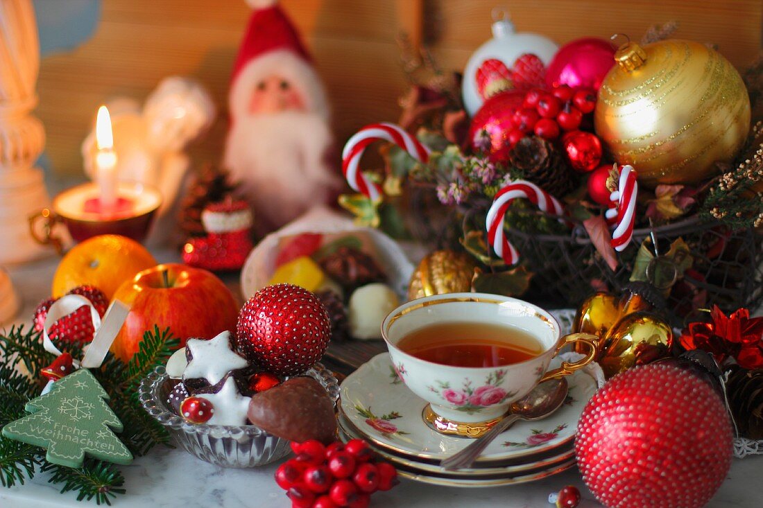 Teetasse mit Rosenmuster, Weihnachtskekse und Weihnachtsdeko
